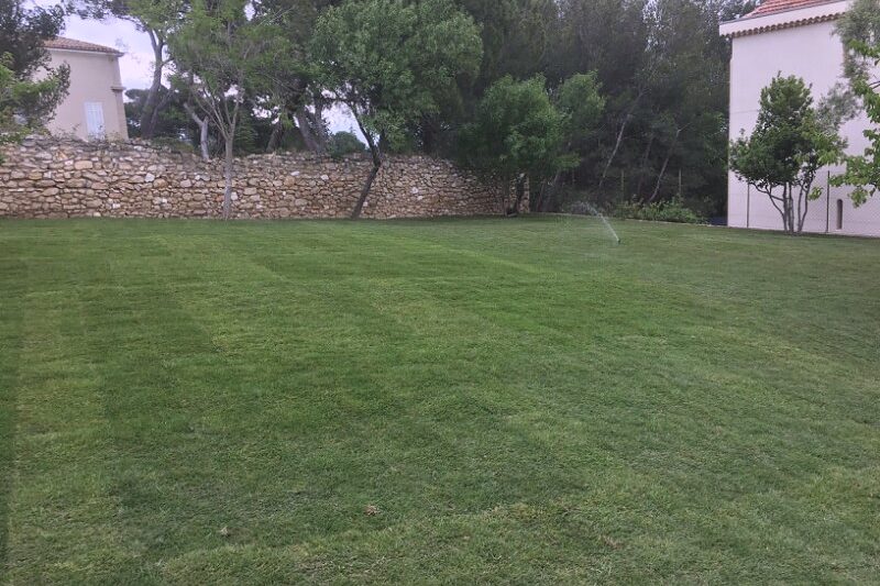 Arroseur automatique en fonctionnement sur une pelouse à Marseille